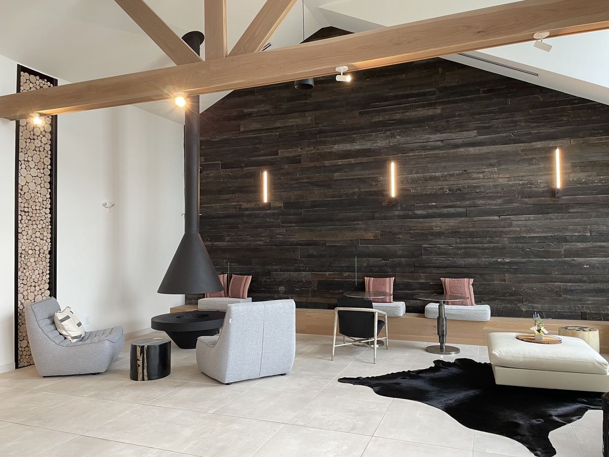 Legacy Heritage — lounge with dark wood accent wall and exposed beams